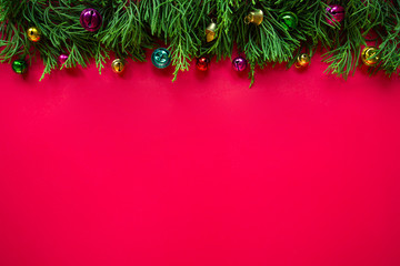 Christmas on the red background,  Pine trees and ornaments on top, Copy space.