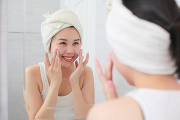 Woman happy cleanses the skin with foam on sink.