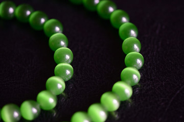 Green stone necklace on a dark background close up