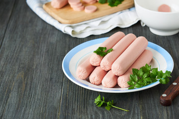 Raw sausages with parsley on a plate