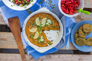 Vegetable pumpkin casserole with green parsley and lemon slices. Vegan lunch, vegetarian dinner, healthy paleo diet. Top down view