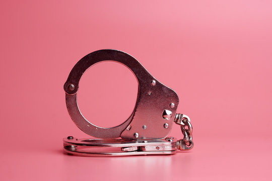 handcuffs on pink background