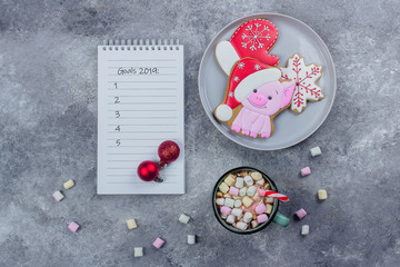 Christmas Gingerbread, Cup of hot cocoa with marshmallows and empty notebook on a gray stone concrete table background. Christmas Holiday Food Concept. Top view with copy space, flat lay