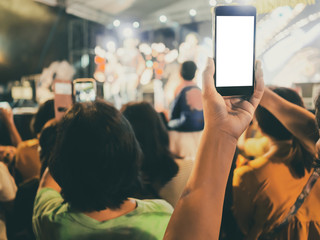 Hands with mobile smart phone recording and taking a picture at music concert