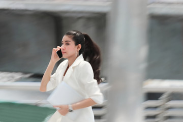Fototapeta premium Abstract blurred motion of young Asian business woman running to work.