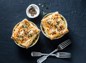 Chicken and vegetables portion pot pie on a dark background, top view. Flat lay