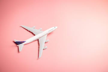 Model plane, top view of airplane on pink color background. travel planning concept