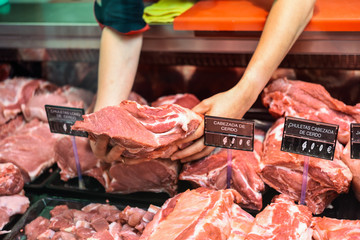 Closeup of butcher's hands holding meat piece in shop