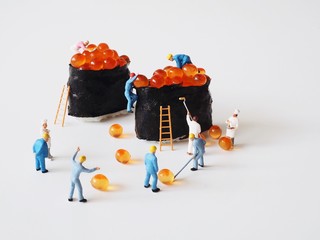 Miniature people prepare a sushi menu on white background.