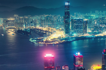Scenic aerial view on Hong Kong, China, by night. Multicolored nighttime skyline with illuminated skyscrapers seen from Victoria Peak.