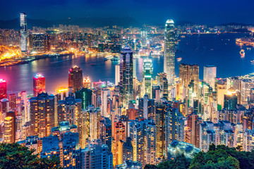 Scenic view over Hong Kong island, China, by night. Multicolored nighttime skyline with illuminated skyscrapers seen from Victoria Peak