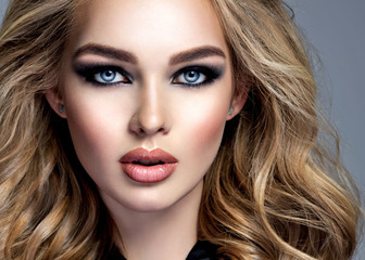 Beautiful blonde girl with  makeup in style smoky eyes.