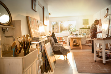 A painter in his studio working on a canvas at sunrise