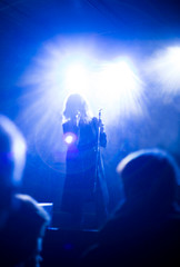 Blurred image with a girl singing.