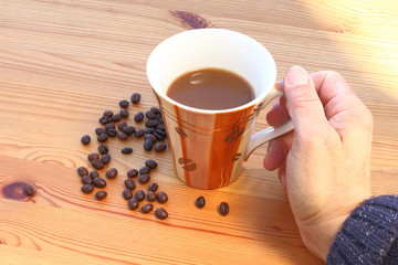 Entspannung, Hand mit Kaffeetasse und Bohnen