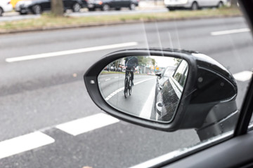 Cyclist in the exterior mirror of a car