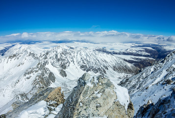 View from the ridge to the top of the snowy mountains to the valley and horizon