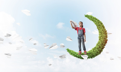 Concept of careless happy childhood with girl on green moon