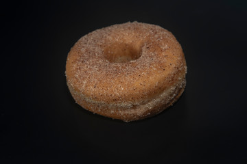 donut with cinnamon sugar black background