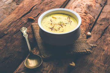 Basundi Or Rabri is an Indian sweet popular in Gujarat and Maharashtra. It is a sweetened condensed milk. Garnished with Dry fruits and Saffron. Served in a bowl over moody background. Selective focus