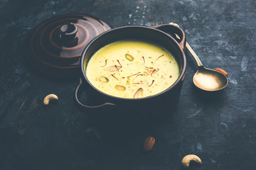 Basundi Or Rabri is an Indian sweet popular in Gujarat and Maharashtra. It is a sweetened condensed milk. Garnished with Dry fruits and Saffron. Served in a bowl over moody background. Selective focus