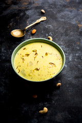 Basundi Or Rabri is an Indian sweet popular in Gujarat and Maharashtra. It is a sweetened condensed milk. Garnished with Dry fruits and Saffron. Served in a bowl over moody background. Selective focus
