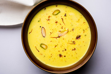 Basundi Or Rabri is an Indian sweet popular in Gujarat and Maharashtra. It is a sweetened condensed milk. Garnished with Dry fruits and Saffron. Served in a bowl over moody background. Selective focus