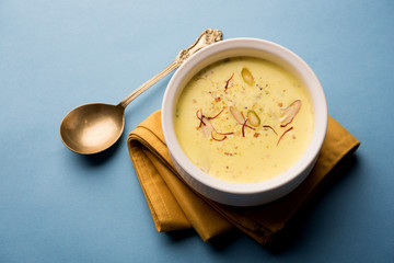 Basundi Or Rabri is an Indian sweet popular in Gujarat and Maharashtra. It is a sweetened condensed milk. Garnished with Dry fruits and Saffron. Served in a bowl over moody background. Selective focus
