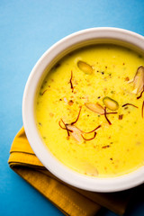 Basundi Or Rabri is an Indian sweet popular in Gujarat and Maharashtra. It is a sweetened condensed milk. Garnished with Dry fruits and Saffron. Served in a bowl over moody background. Selective focus