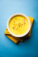 Basundi Or Rabri is an Indian sweet popular in Gujarat and Maharashtra. It is a sweetened condensed milk. Garnished with Dry fruits and Saffron. Served in a bowl over moody background. Selective focus