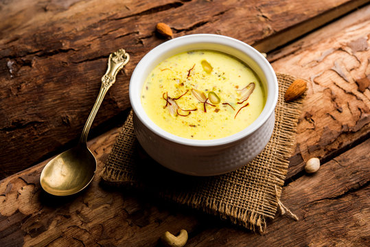 Basundi Or Rabri is an Indian sweet popular in Gujarat and Maharashtra. It is a sweetened condensed milk. Garnished with Dry fruits and Saffron. Served in a bowl over moody background. Selective focus