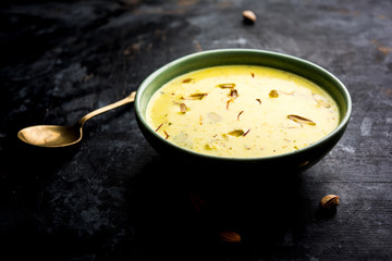 Basundi Or Rabri is an Indian sweet popular in Gujarat and Maharashtra. It is a sweetened condensed milk. Garnished with Dry fruits and Saffron. Served in a bowl over moody background. Selective focus