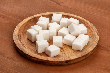 A photo of sugar cubes on a dark rustic wooden background with a place for text