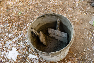 Two spatulas in bucket with the mortar