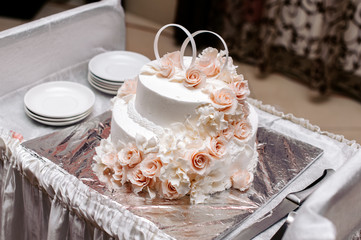 Obraz na płótnie Canvas White wedding cake with flowers and rings