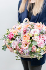 Beautiful spring bouquet in wicker basket. Arrangement with various flowers. The concept of a flower shop. A set of photos for a site or catalogue. Work florist.