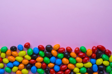 Tasty colorful candies on pink background. Flat lay