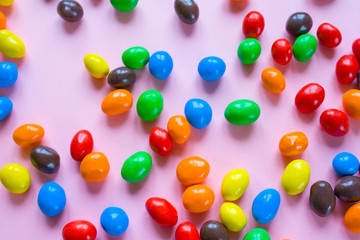 Obraz premium Tasty colorful candies on pink background. Flat lay
