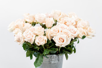 Pastel color. Beautiful light pink roses in bucket on street flower market. Rose flower holiday background.