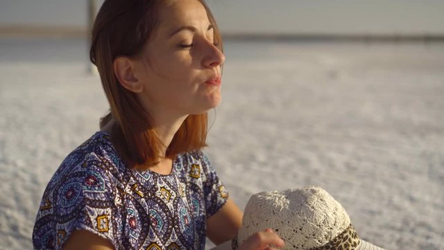 happy smiling girl enjoying the sunset, eating watermelon, sit on salt, close-up