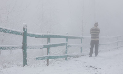 man in the fog at the fence,winter landscape