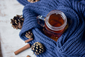 Autumn still life. cup of tea, Scarf and cinnamon sticks on wooden background.