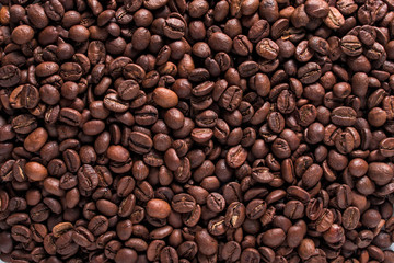 Arabica roasted coffee beans scattered close-up, texture of fragrant coffee beans