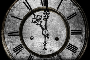 worn clock with roman numerals on a black background, old age concept