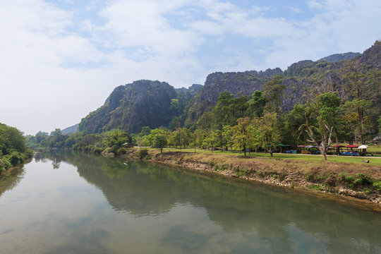 Nam Song River and limestone karst mountains near the Tham Chang (or Jang or Jung) Cave in Vang Vieng, Laos, on a sunny day.