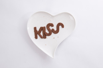 Obraz premium Word kiss cookies on the white heart plate