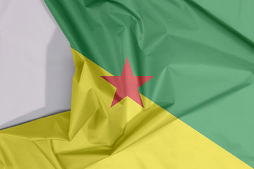 French Guiana fabric flag crepe and crease with white space, The green and yellow with red star.