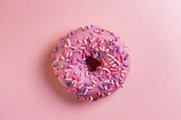 Single round donut on pink background.