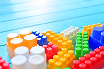 Children’s toy background. Building kit bricks on a blue background with a copy space. Early learning concept.