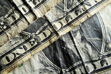 Naklejka premium Dolar USA close-up. Old battered crumpled bills macro. The texture of the fragment of the dollar bill. USD banknote texture.